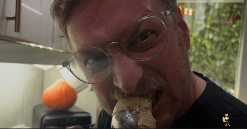 Ein Smart Home Fox Tester beißt begeistert in eine Kugel selbstgemachtes Eis aus der Ninja Creami.